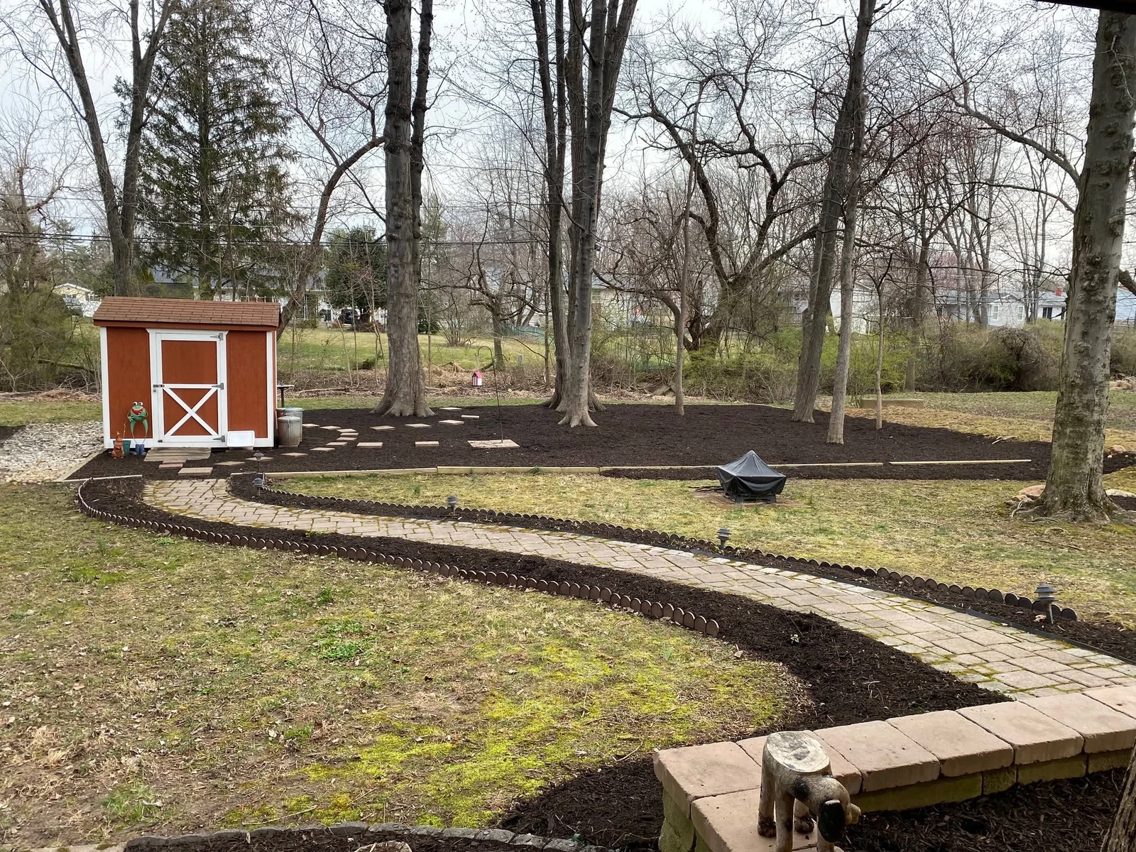 Fresh mulch around mature trees and a gently curving garden path — Dylan’s Lawn Care